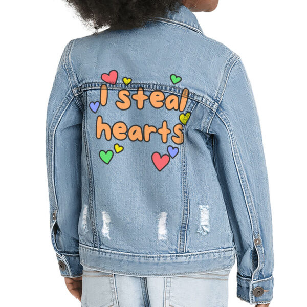 Toddler wearing a denim jacket with "I Steal Hearts" design.