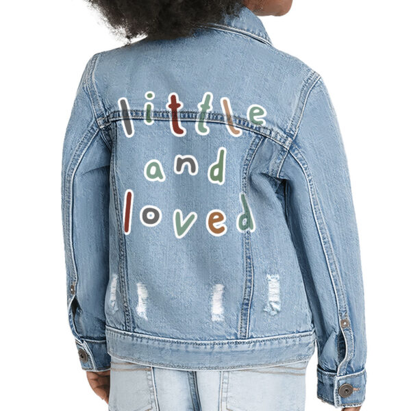 Trendy toddler wearing 'Little and Loved' denim jacket.