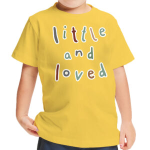 Toddler wearing a white t-shirt with "Little and Loved" print.